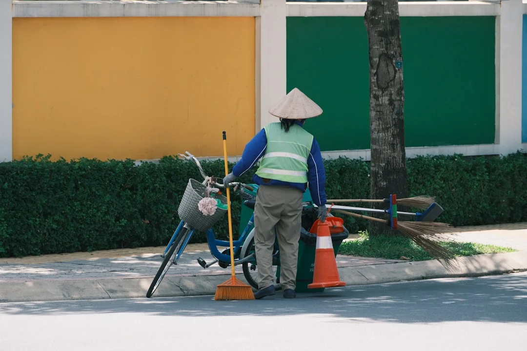A person in personal protective equipment vacuuming indoors, ensuring a thorough clean.